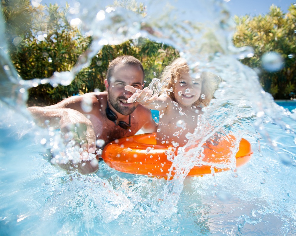 Spaß im Naturpool mit orangem Schwimmring